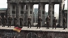 Ostdeutsche Grenzpolizisten stehen auf der Berliner Mauer | Bild: dapd