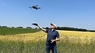 Hobby-Luftbild-Archäologe Stefan Kluthe mit seiner Drohne auf einem Feld bei Fürstenfeldbruck | Bild: BR / Anna-Elena Knerich