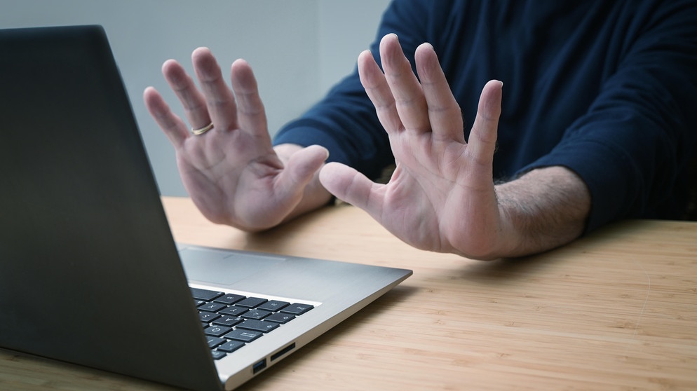 Hände in abwehrender Haltung gegen einen Laptop  | Bild: picture alliance / Zoonar | Maren Winter