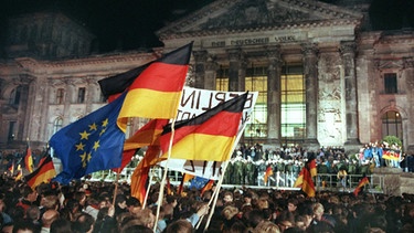 Rund eine Million Menschen feierten in der Nacht zum 3. Oktober 1990 in Berlin wie hier vor dem Reichstagsgebäude die wiedergewonnene deutsche Einheit.  | Bild: picture-alliance/dpa Fotograf:Wolfgang Kumm