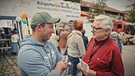 Hannes Schmidt (rechts) vom Bürgerforum Fuchstal im Gespräch mit einem Besucher des Frühlingsmarktes | Bild: BR