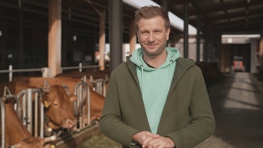 "Unser Land"-Moderator Florian Kienast im Stall | Bild: BR/Andrea Mittlmeier