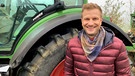 "Unser Land"-Moderator Florian Kienast im Kuhstall | Bild: BR/Jutta Schilcher