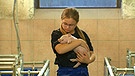 Mädchen mit Ferkel im Schweinestall | Bild: BR