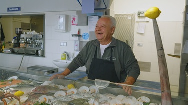 Fischhändler Luigi Schirone in seinem Fischgeschäft in Holzheim bei Ampfing. Guter Kunde ist Toni Krank.  | Bild: BR/Raimund Lesk