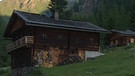 Unter unserem Himmel - Das Villgratental in Osttirol: Zwei Holzhäuser auf grüner Wiese, im Hintergrund Berge | Bild: BR