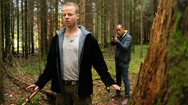 Jerry Paulsen (Peter Marton, rechts) nimmt Markus von Mahnfeld (Martin Wißner, links) die Waffe ab – Monika war's nicht, behauptet er. | Bild: ARD/Lucky Bird Pictures/Angela M. Schlabitz