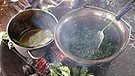 Gemüse kochen in zwei Töpfen, die auf einem Lagerfeuer stehen. | Bild: Rainer Schall