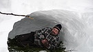 Rainer Schall liegt in einer Schneehöhle an einem norwegischen Fjell. | Bild: Rainer Schall