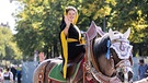 Das Münchner Kindl Franziska Inselkammer führte den traditionellen Festzug der Wiesnwirte von einem Kaltblüter aus winkend an. | Bild: BR/Markus Konvalin