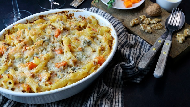 eine weiße Schale Nudelauflauf mit Kürbis, Gorgonzola und Walnüssen, der mit Käse überbacken ist, auf einem Küchentuch; Ansicht von oben; | Bild: mauritius images / Grazziela Bursuc / Alamy / Alamy Stock Photos