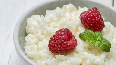 
Milchreis im Schälchen garniert mit Himbeeren | Bild: mauritius images / foodcollection / Nils Melzer