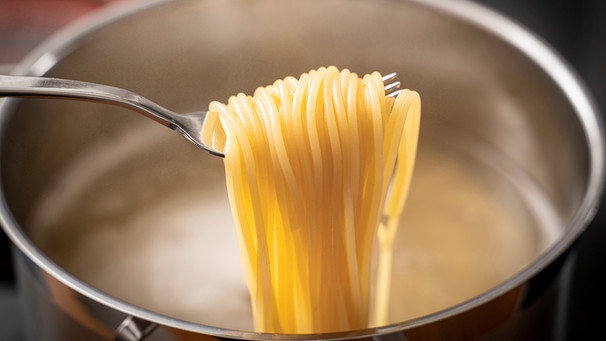 Spagetti mit der Gabel über einem Kochtopf aufgerollt | Bild: mauritius images / Chromorange / Michael Bihlmayer