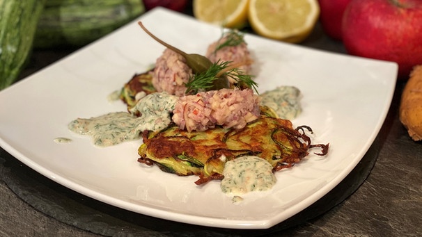 Matjestatar mit Zucchini-Kartoffel-Rösti auf einem Teller serviert.  | Bild: BR