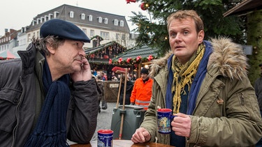 Jens Stellbrink geht mit seinem Kollegen auf den Weihnachtsmarkt und erzählt ihm interessante Neuigkeiten. | Bild: SR / Manuela Meyer