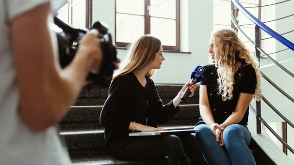 Eine junge Frau interviewt eine andere. Ein junger Mann filmt das Gespräch. | Bild: BR/Sylvia Bentele