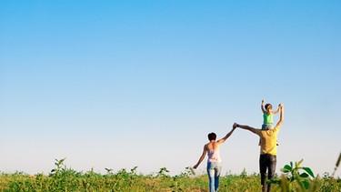 Familie von hinten auf einer Wiese | Bild: colourbox.de