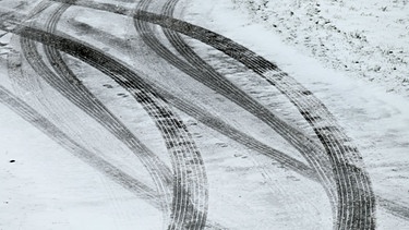 20.11.2024, Hessen, Willingen: Reifenspuren zeichnen sich auf dem schneebedeckten Asphalt ab. In den Höhenzügen des Waldeckischen Uplands hat der Winter Einzug gehalten. | Bild: dpa-Bildfunk/Uwe Zucchi