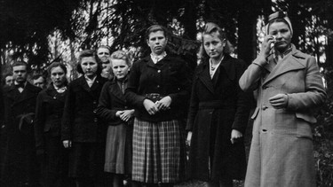 Warsteiner Bürger, die Anfang Mai 1945 auf Befehl der US-Army an den Leichen der in den Wäldern ermordeten Zwangsarbeiter vorbeilaufen mussten. | Bild: WDR/probono Fernsehproduktion GmbH/Max Neidlinger