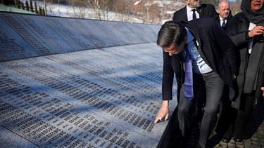 Der niederländische Ministerpräsident Mark Rutte berührt das Denkmal mit den Namen der Opfer des Völkermordes von Srebrenica in der Gedenkstätte Srebrenica.  | Bild: dpa-Bildfunk/Armin Durgut