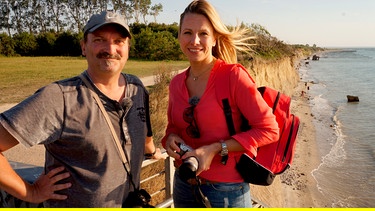Moderatorin Andrea Grießmann mit Fotograf Frank Burger (links) an der Steilküste von Ahrenshoop. | Bild: BR/WDR/Linda Windmann