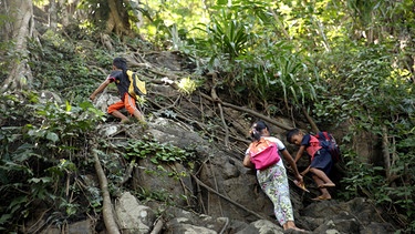 Diese Kinder aus Madibago im Südwesten der Philippinen haben einen der außergewöhnlichsten und gefährlichsten Schulwege der Welt. Denn um ihre Schule zu erreichen; müssen schon die Siebenjährigen eine Steilwand mitten im Dschungel erklimmen. Lediglich ein paar Wurzeln geben den Schülern etwas Halt. | Bild: MDR/Maximus Film GmbH