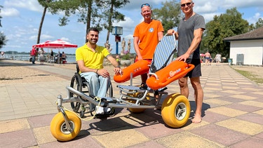 Tan Caglar, Bademeister Lutz Riemann, Schwimmender Rollstuhl - Strandbad Arendsee. | Bild: MDR/Jonas Juckeland