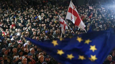 04.11.2024, Georgien, Tiflis: Demonstranten schwenken EU- und georgische Nationalflaggen, während sie an einer Kundgebung gegen angebliche Verstöße bei den jüngsten Parlamentswahlen teilnehmen. | Bild: dpa-Bildfunk/Zurab Tsertsvadze