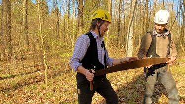 Mathias Gläser und Jan Vockel. Die beiden sind Zimmerermeister und Restauratoren im Handwerk. Sie fällen die Esche mit Äxten, zersägen dann den Stamm und zeigen mit alten Techniken, wie man aus dem Rundholz optimal einen eckigen Balken arbeitet. | Bild: SWR