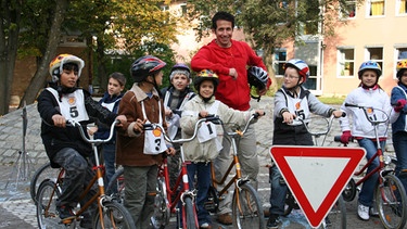 Schüler der Grundschule Balanstraße mit Willi bei der Fahrradprüfung. Heute geht's um die Sicherheit im Straßenverkehr. | Bild: BR/megaherz gmbh/