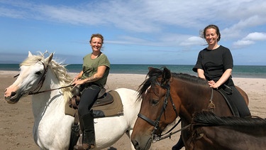 Vor einem Ausritt müssen Justine und Stephy (v.l.n.r.) ihre Pferde erst einfangen. Die Tiere leben im Sommer frei auf der Insel Miquelon-Langlade. | Bild: NDR/Florianfilm