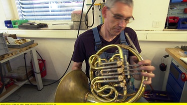 Blasinstrumentenbauer Eckard Graf prüft das von ihm gebaute Horn. | Bild: SWR