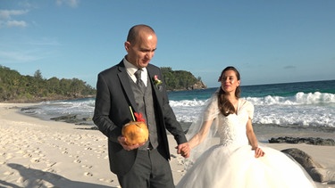 Urlaub auf den Seychellen – oder gar dort heiraten? Die Inselgruppe ist für viele ein Traum, vor allem für Deutsche, die hier die Gästeliste zahlenmäßig anführen. - Hochzeitspaar am weißen Strand. | Bild: WDR