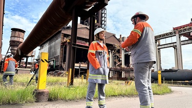 Die Stahlindustrie, hier das Werk von ArcelorMittal in Bremen, will ihre Produktion auf grünen Stahl umstellen. ARD-Wissen Presenterin Lena Ganschow besucht das Werk. | Bild: EWE/BR/Nadine Auras