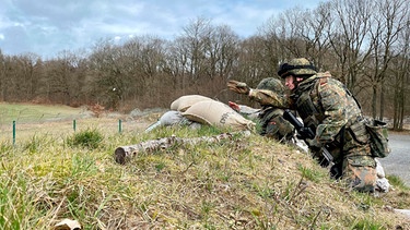 Zwei Soldaten der Heimatschutzkompanie Hamburg sichern das Übungsgelände. Früher standen 900 Soldaten auf Knopfdruck bereit, heute sollen 144 ehrenamtliche Reservisten die Hansestadt im Kriegsfall schützen. | Bild: NDR/Katrin Hafemann