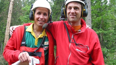 Willi und Andreas (rechts) befestigen Stahlschlingen um Baumstämme, die dann später mit dem Helikopter abtransportiert werden. | Bild: BR/megaherz gmbh/