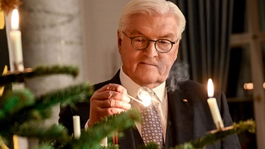 Bundespräsident Frank-Walter Steinmeier zündet im Schloss Bellevue an einem Weihnachtsbaum die Kerzen an. | Bild: picture-alliance/dpa