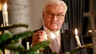 Bundespräsident Frank-Walter Steinmeier zündet im Schloss Bellevue an einem Weihnachtsbaum die Kerzen an. | Bild: picture-alliance/dpa