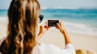 Influencerin macht Foto am Strand | Bild: Unsplash/ Katja Hentschel