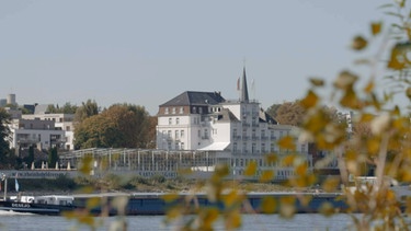 Das Rheinhotel Dreesen im Spätsommer 2021, gesehen von der gegenüberliegenden Rheinseite. | Bild: BR, WDR, Zeitsprung Pictures