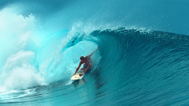 Ein professioneller Surfer reitet eine Welle. | Bild: stock.adobe.com/helivideo