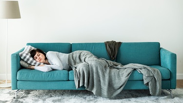 Eine Frau schläft auf dem Sofa | Bild: stock.adobe.com/Rawpixel.com