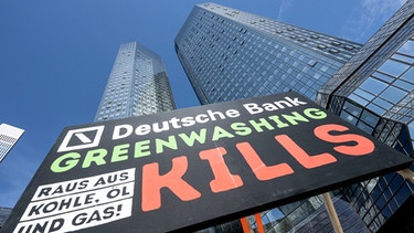 28.06.2022, Hessen, Frankfurt/Main: «Deutsche Bank - Greenwashing kills, raus aus Kohle, Öl und Gas!» steht auf einem Plakat, das Umweltaktivisten von Fridays for Future vor der Zentrale der Deutschen Bank aufgestellt haben. Foto: Boris Roessler/dpa +++ dpa-Bildfunk +++ | Bild: dpa-Bildfunk/Boris Roessler