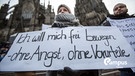 Eine Frau protestiert am 10.01.2016 in Köln (Nordrhein-Westfalen) vor dem Hauptbahnhof und dem Dom gegen sexuelle Gewalt mit einem Plakat "Ich will mich frei bewegen - ohne Angst, ohne Vorurteile". Nach den sexuellen Übergriffen auf Frauen in der Silvesternacht verstärkt die Polizei die Präsenz am Hauptbahnhof. Foto: Maja Hitij/dpa | Bild: picture alliance / dpa | Maja Hitij