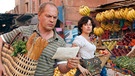 Kurt (Uwe Ochsenknecht) und Mona (Carolina Vera) kaufen gemeinsam auf einem orientalischen Markt ein. | Bild: ARD Degeto/Erika Hauri