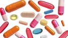 Mehrere bunte herabfallende Tabletten und Kapseln vor weißem Hintergrund. | Bild: stock.adobe.com/Pixel-Shot