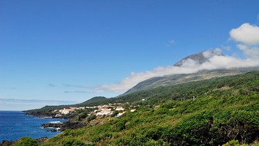 Der Ort São João an der Südküste Picos. Im Hintergrund ist der Vulkan Ponta do Pico zu sehen. | Bild: HR/Reinhard Mink