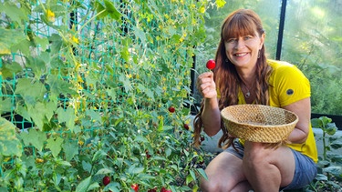 Sabrina Nitsche mit Kirschpaprika im Querbeet-Garten. | Bild: Tobias Bode