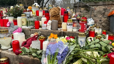 24.01.2025, Aschaffenburg - Zwei Tage nach dem Messerangriff liegen Blumen, Kerzen und Stofftiere in der Nähe des Tatorts. | Bild: BR/Pirmin Breninek