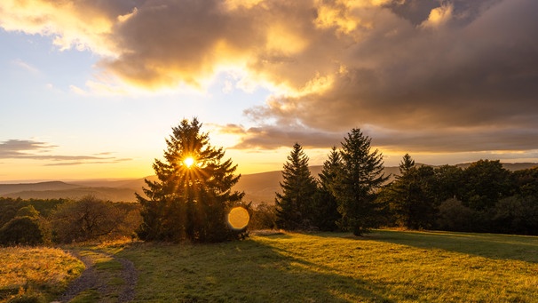 Die Abendsonne scheint auf die Landschaft am Kreuzberg in der Rhön.  | Bild: picture alliance / Jan Eifert | Jan Eifert